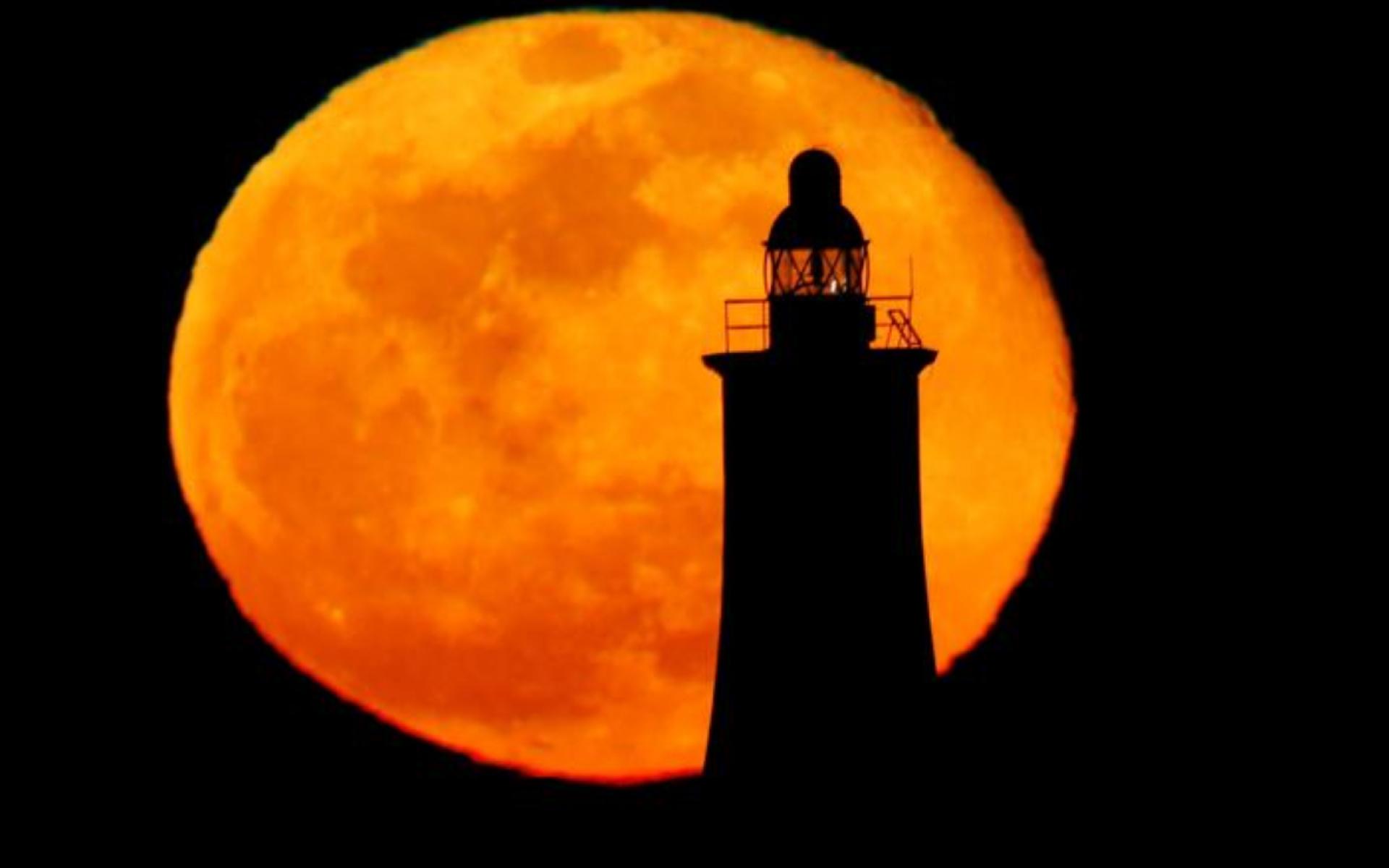 صورة للقمر العملاق خلف منارة بمدينة فاليتا في مالطا