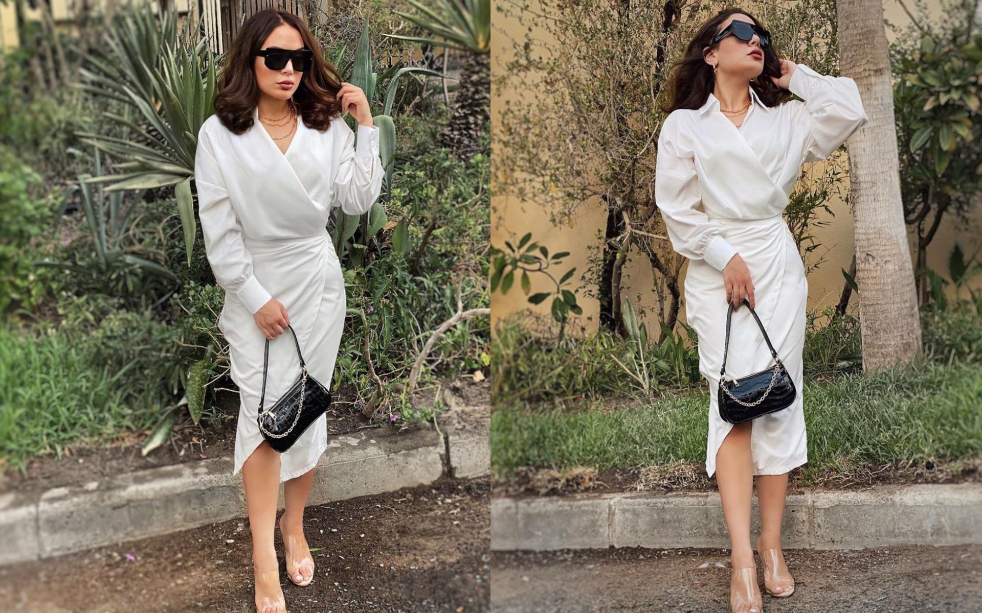 قميص أبيض وتنورة بنفس اليوم تقريباً مع حقيبة يد جلد باللون الأسود لإطلالة رسمية